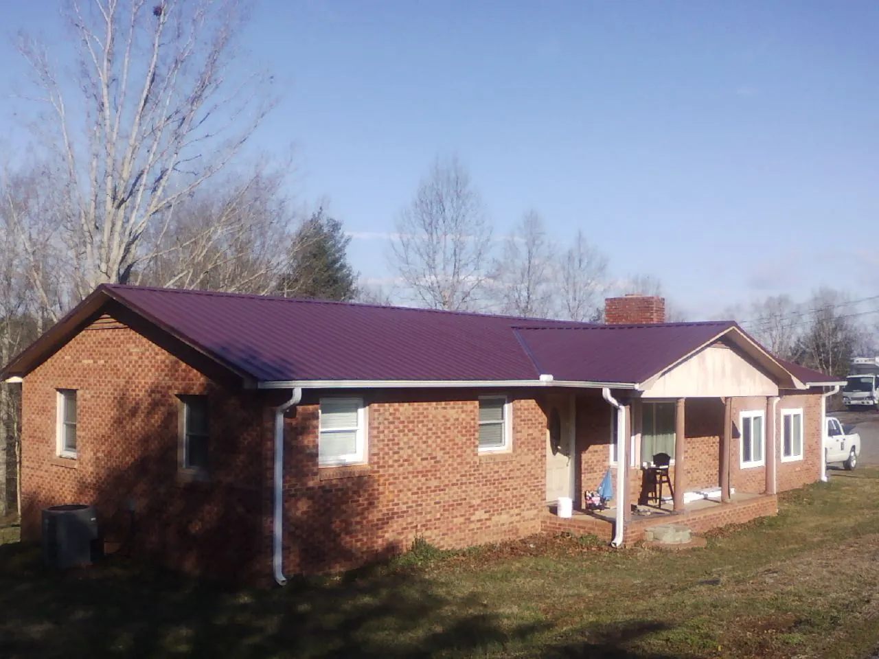 Burgundy metal roof on a brick ranch home with a new addition in North Billerica