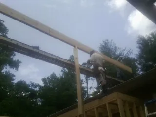 Carpenter setting a ridge beam over a new addition frame — Ice Dam Removal by Roofing Brothers in North Billerica