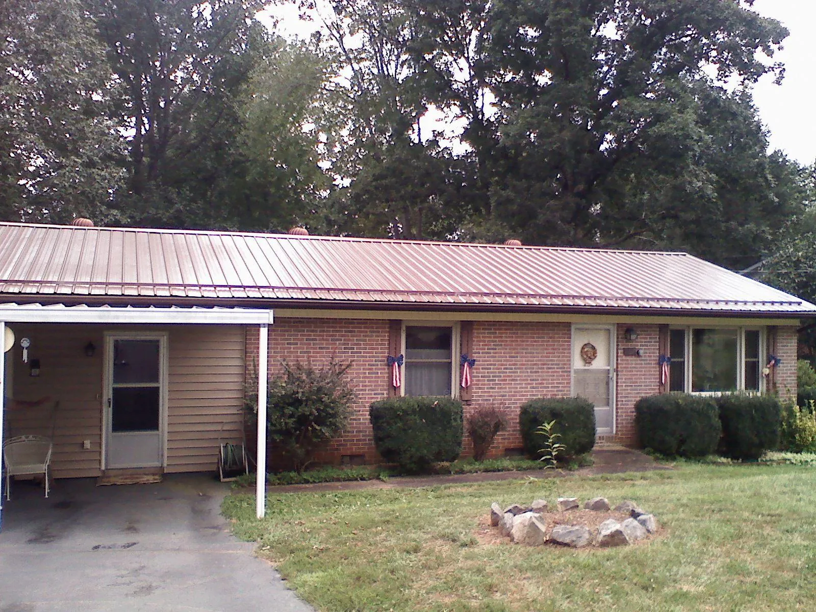 Bronze metal roof and carport on a brick ranch home — Roof Repair work by our crew in North Billerica